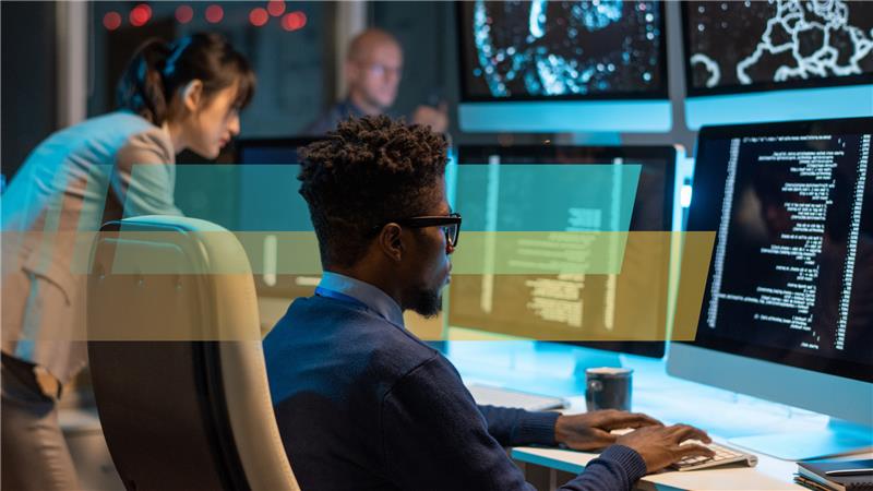 Man looking at PC with other people in background
